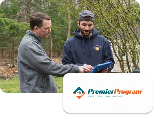 Two men stand outside; one in a gray jacket, the other in a blue hoodie holding a tablet. The Premier Program logo appears in the lower right corner.